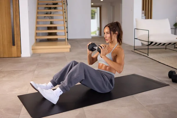 Kayla Itines seated with dumbbell