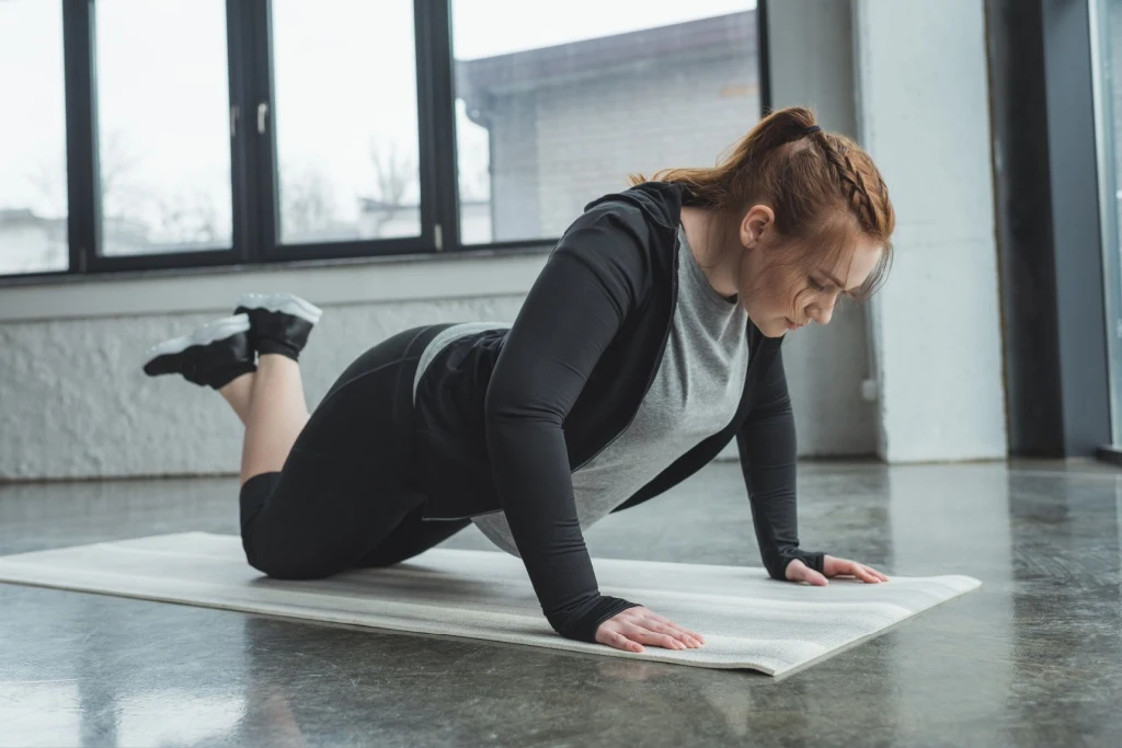 Woman doing pushup on knees