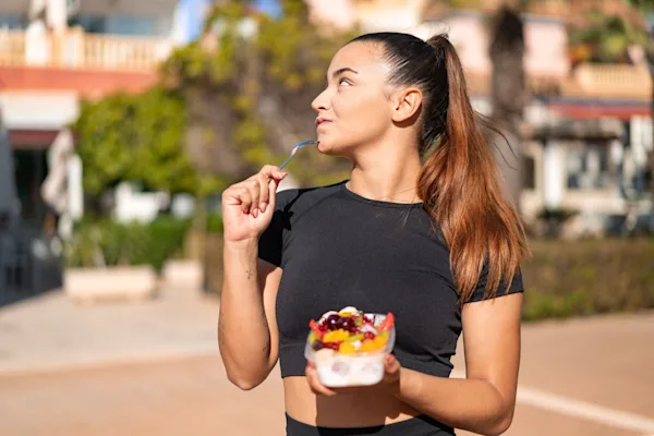 Woman eating yoghurt and fruit
